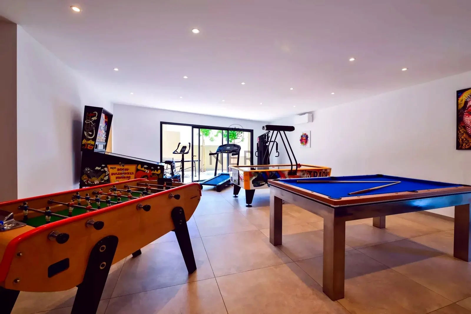 Salle de jeux et espace sport de la Villa A Pinnata avec billard, baby-foot, jeux d’arcade et appareils de fitness