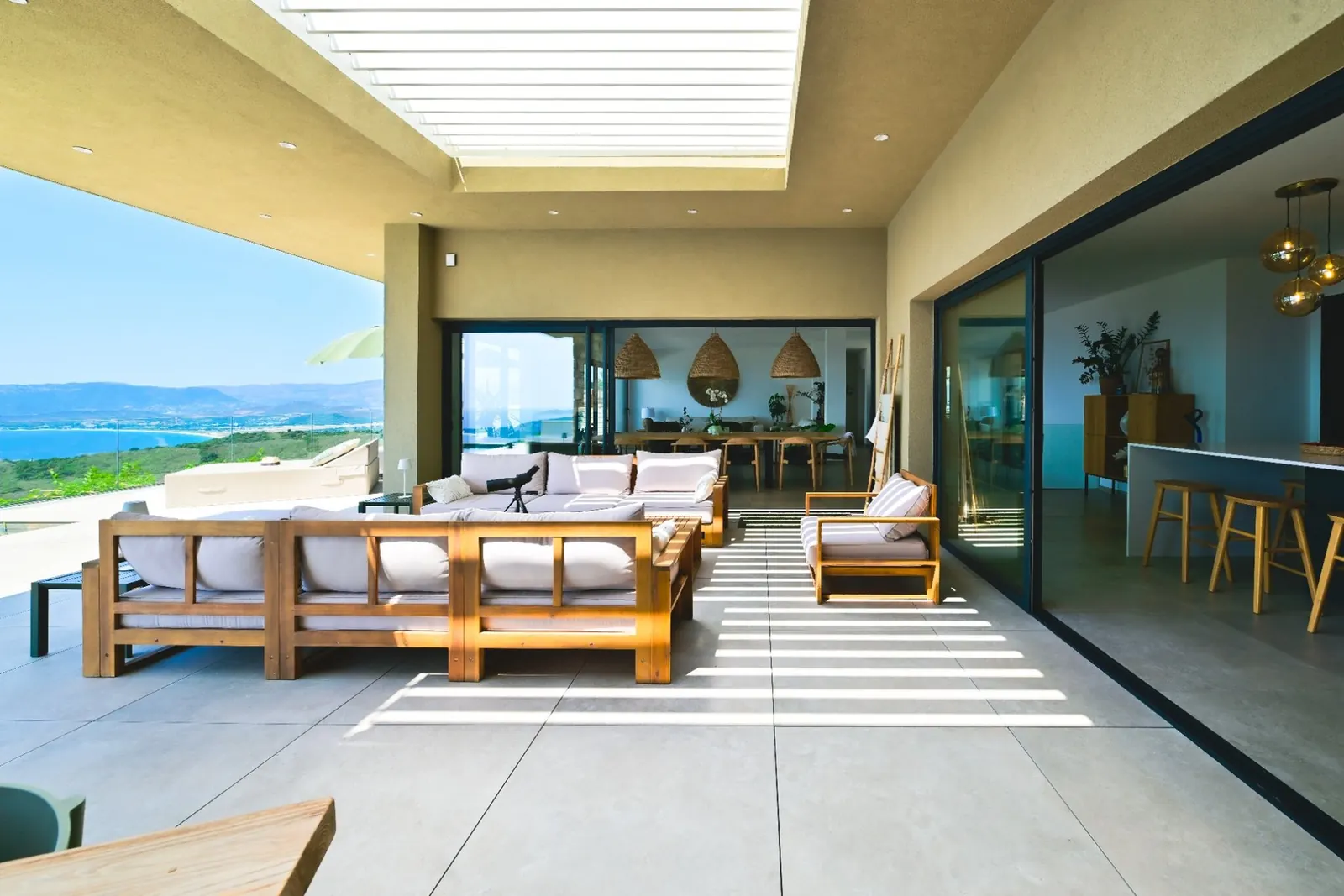 Terrasse couverte de la Villa A Pinnata ouverte sur la piscine et le golfe d’Ajaccio